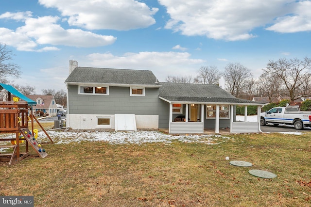 view of front of property with a playground and a front lawn