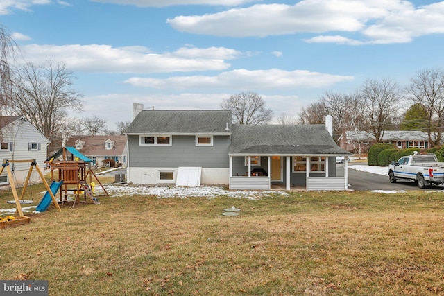 view of front facade with a playground, a front lawn, and a porch