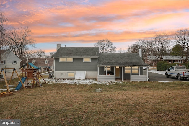 view of front facade featuring a playground and a yard