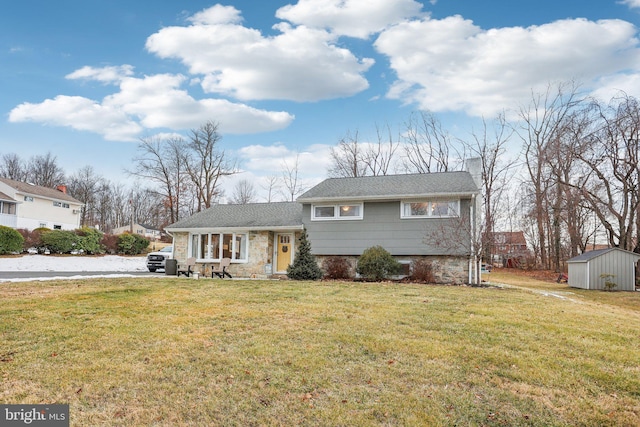 tri-level home with a shed and a front yard