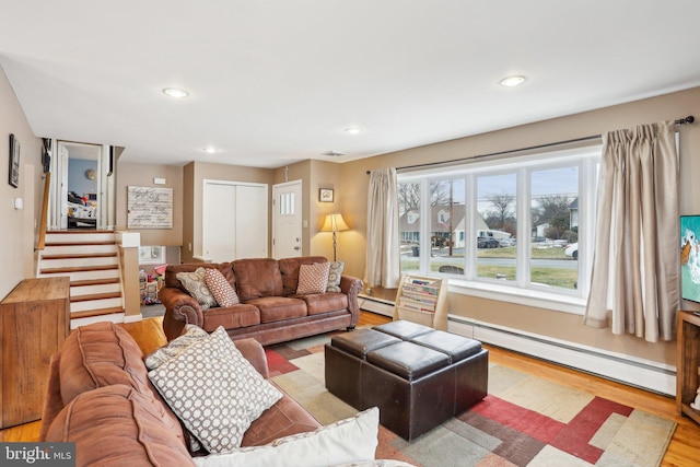 living room with light wood-type flooring and a baseboard radiator