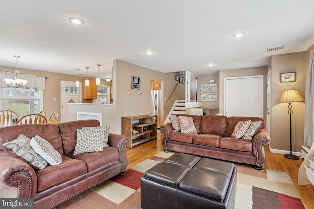 living room featuring light hardwood / wood-style flooring and a notable chandelier