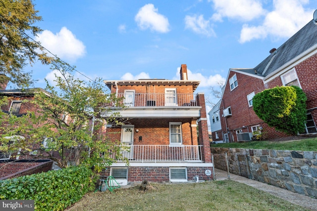 exterior space featuring a balcony, a porch, and a front yard