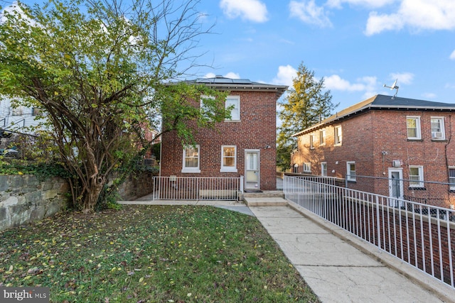 rear view of property with a lawn