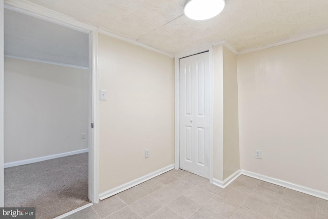 unfurnished bedroom featuring crown molding and a closet