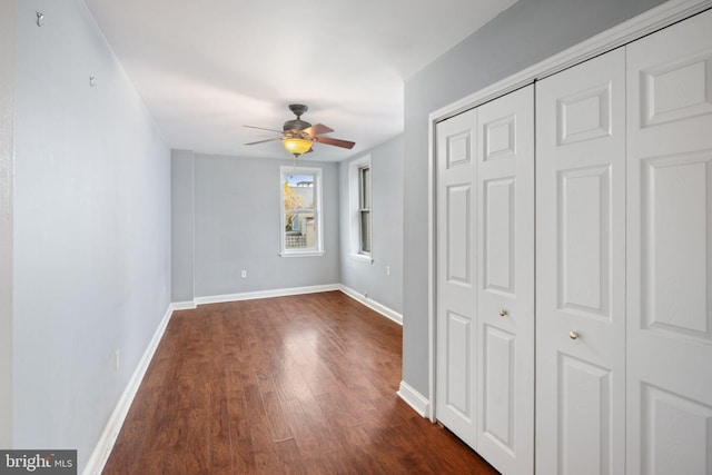 unfurnished bedroom featuring ceiling fan and dark hardwood / wood-style flooring