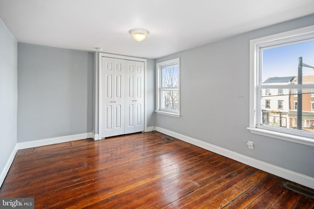 unfurnished bedroom with a closet and dark wood-type flooring