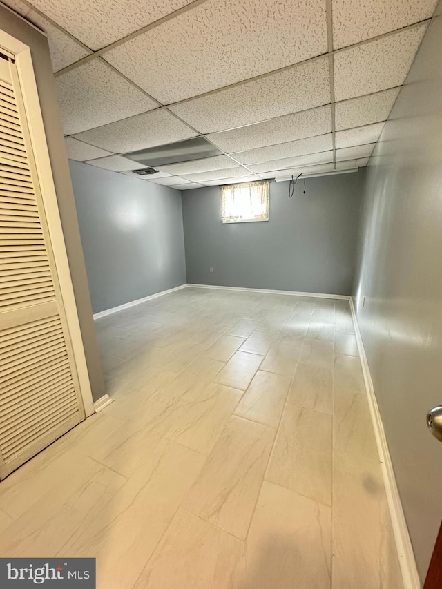 basement with a paneled ceiling