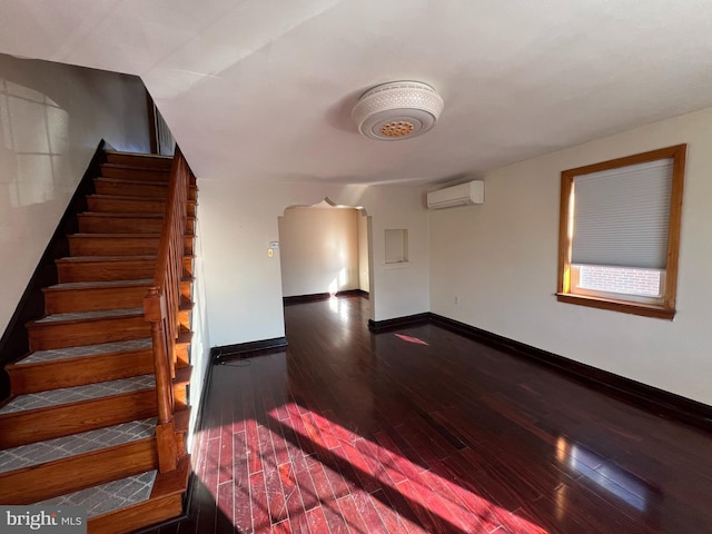 empty room with hardwood / wood-style flooring and a wall unit AC