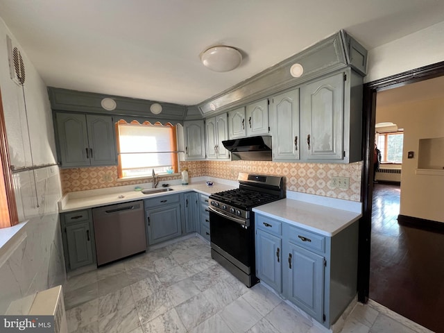 kitchen featuring radiator, stainless steel appliances, tasteful backsplash, and sink