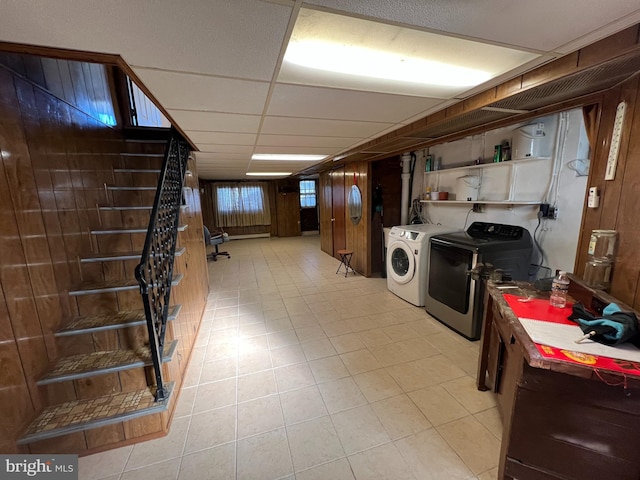 clothes washing area featuring washing machine and dryer and wooden walls