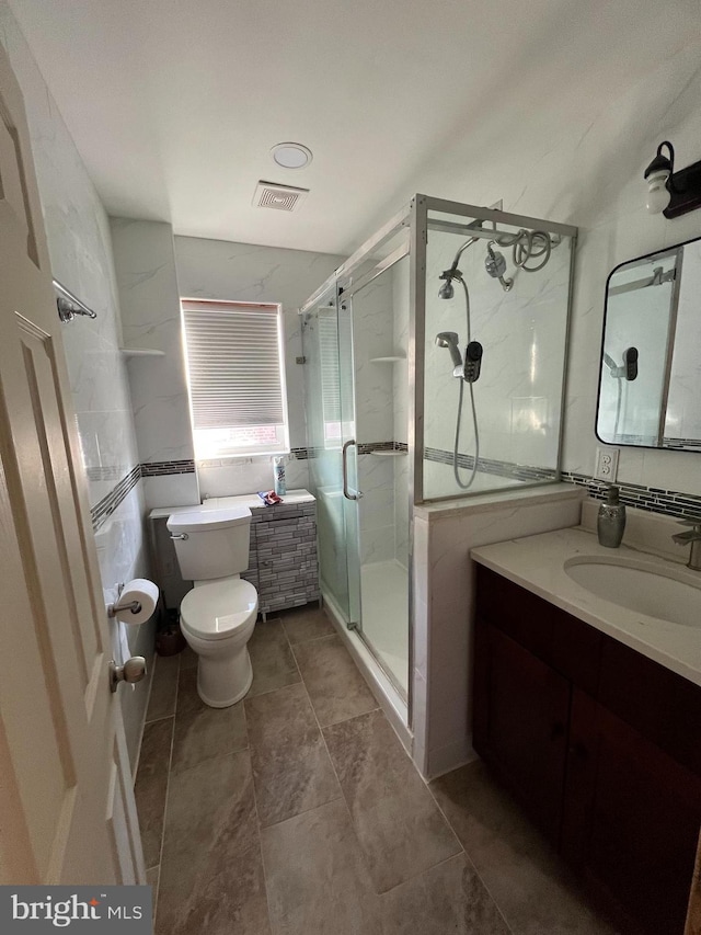 bathroom with a shower with door, vanity, and toilet