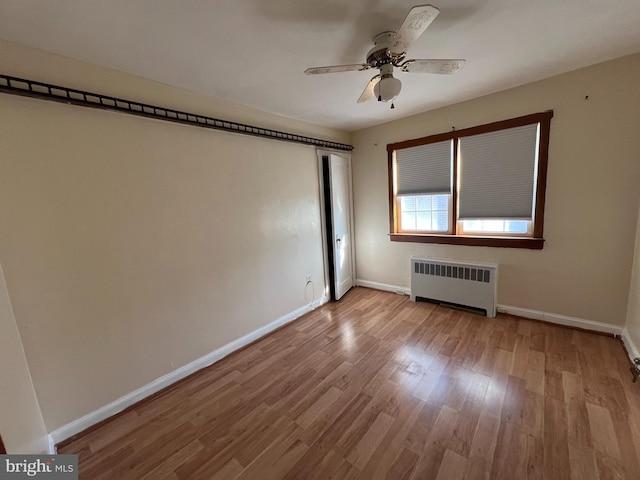 interior space with radiator, ceiling fan, and light hardwood / wood-style floors