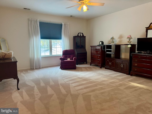 living area with ceiling fan and light carpet