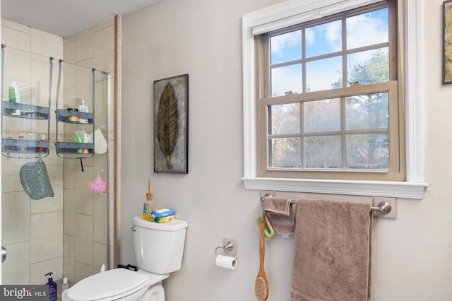 bathroom featuring toilet and a shower with shower door