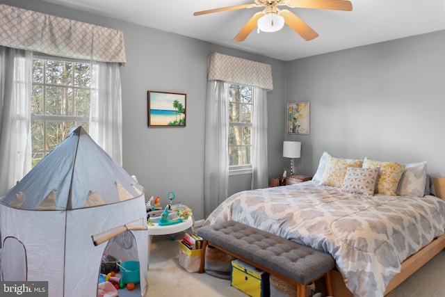 bedroom with carpet flooring, multiple windows, and ceiling fan