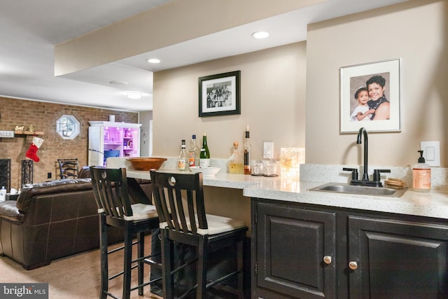 bar featuring sink, brick wall, and light carpet