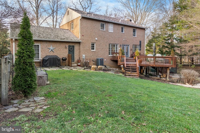 rear view of house featuring central air condition unit, a deck, and a lawn