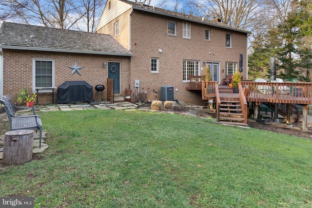 rear view of house featuring a yard, cooling unit, and a wooden deck