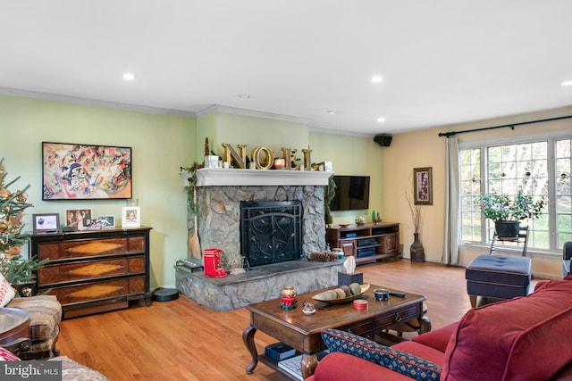 living room featuring a fireplace, hardwood / wood-style floors, and ornamental molding