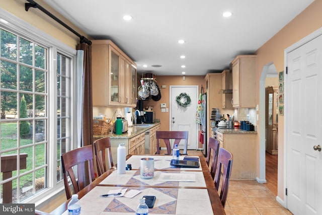 tiled dining space featuring a healthy amount of sunlight and sink