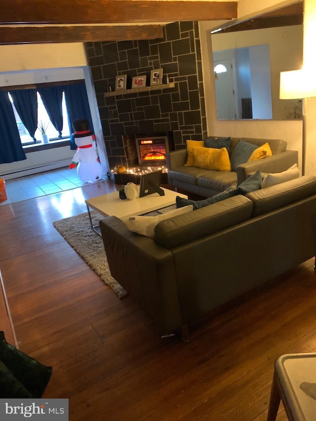 living room with hardwood / wood-style flooring, a stone fireplace, and baseboard heating