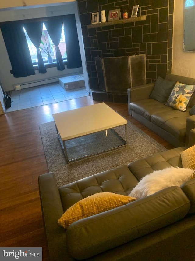 tiled living room with a stone fireplace