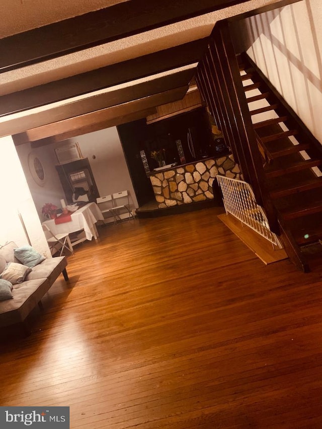 unfurnished living room featuring beam ceiling and wood-type flooring