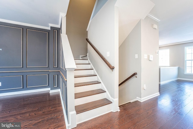 stairs with ornamental molding and hardwood / wood-style floors