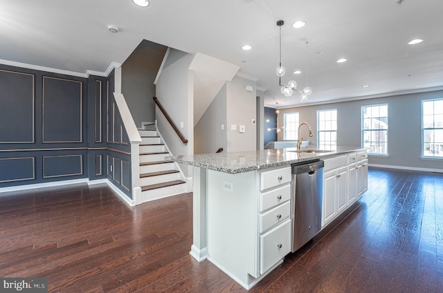 kitchen with white cabinets, light stone counters, an island with sink, stainless steel dishwasher, and hanging light fixtures