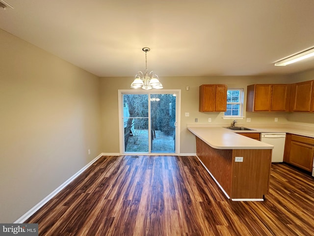 kitchen featuring a notable chandelier, kitchen peninsula, white dishwasher, hanging light fixtures, and dark hardwood / wood-style flooring