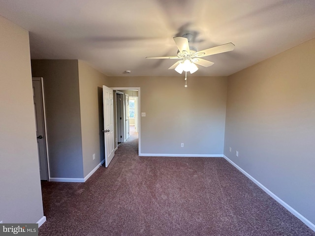 unfurnished room featuring ceiling fan and dark carpet