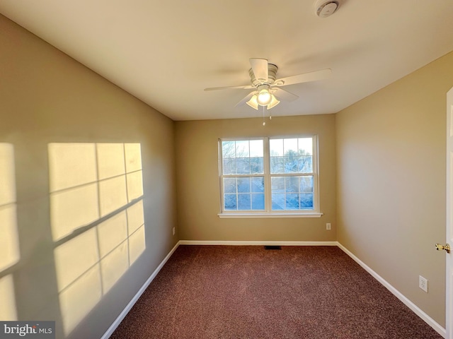 carpeted spare room featuring ceiling fan