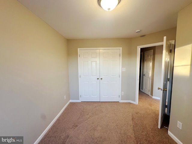 unfurnished bedroom with a closet and carpet flooring