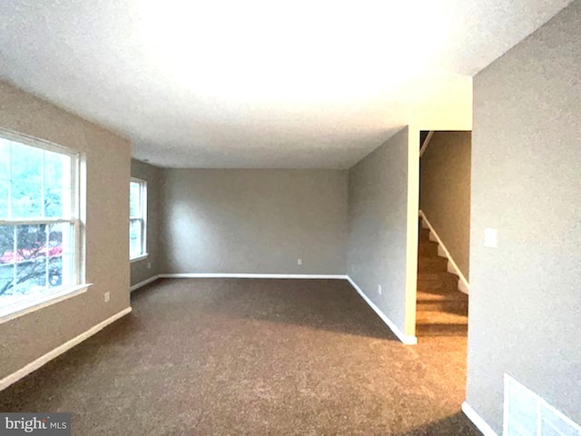 spare room featuring a textured ceiling and carpet flooring