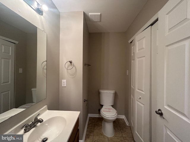 bathroom featuring toilet, tile patterned flooring, and vanity