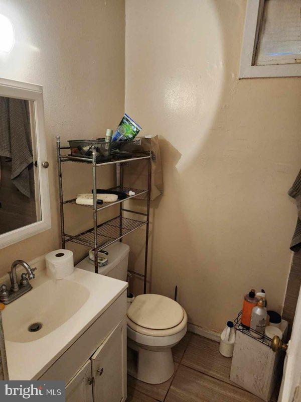 bathroom with hardwood / wood-style flooring, vanity, and toilet