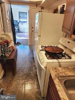 interior space with white range with gas cooktop and light stone countertops