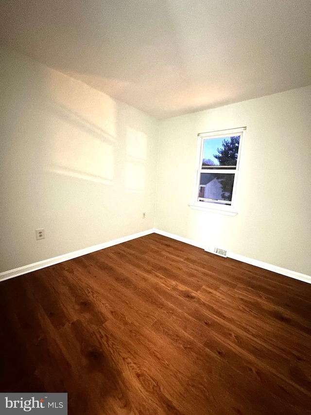 spare room featuring dark wood-type flooring