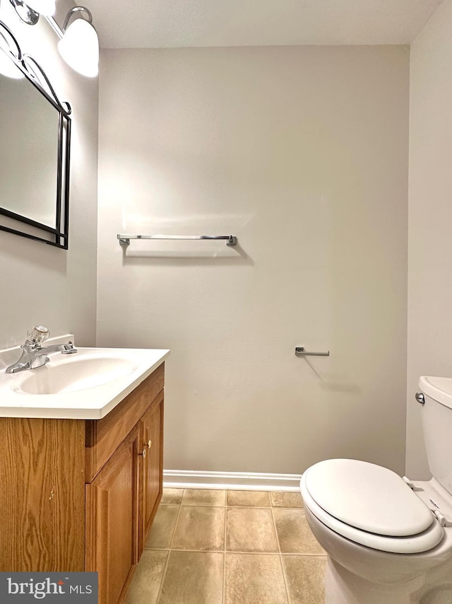 bathroom with toilet, tile patterned flooring, and vanity