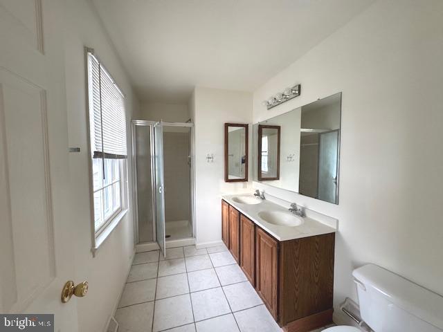 bathroom with toilet, an enclosed shower, tile patterned flooring, and vanity