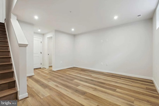 basement with light hardwood / wood-style flooring