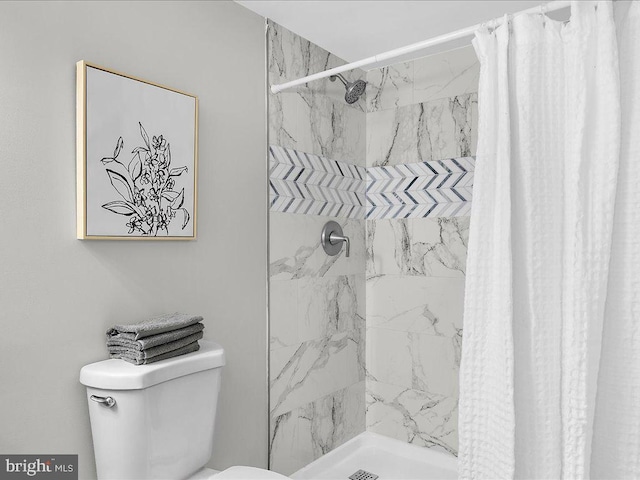 bathroom featuring a shower with curtain and toilet