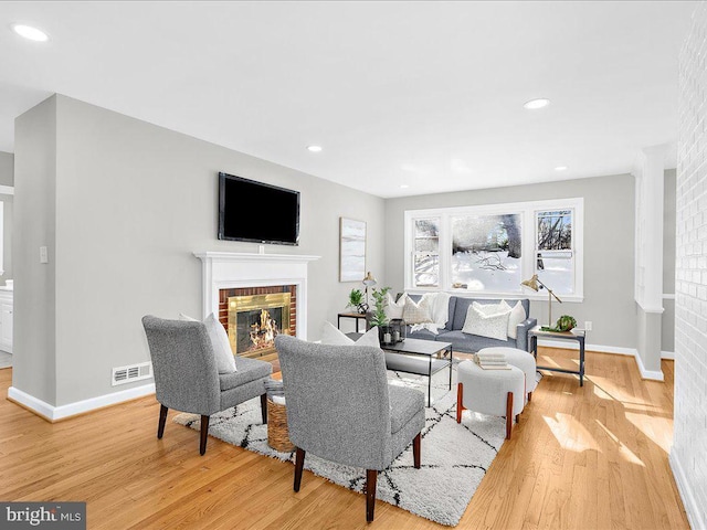 living room featuring hardwood / wood-style floors and a brick fireplace