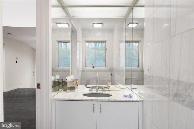 bathroom featuring vanity and tile walls