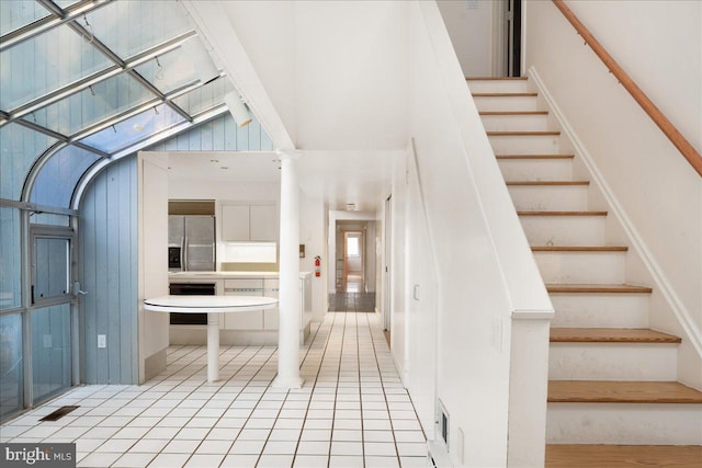 stairway featuring a high ceiling and tile patterned floors