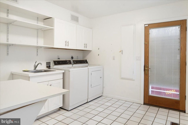 laundry area featuring washer and dryer, cabinets, light tile patterned floors, and sink