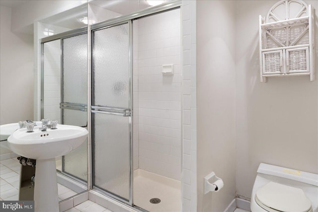 bathroom with toilet, tile patterned flooring, a shower with shower door, and sink