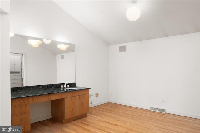 bathroom featuring sink, hardwood / wood-style floors, and vaulted ceiling