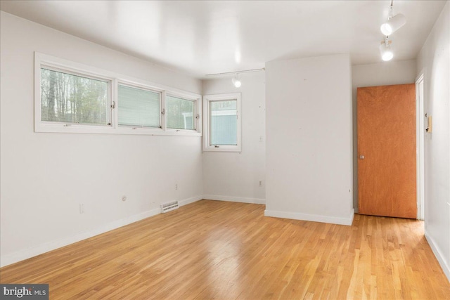 spare room featuring light hardwood / wood-style floors and a healthy amount of sunlight